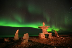 Churchill inukshuk under aurora.