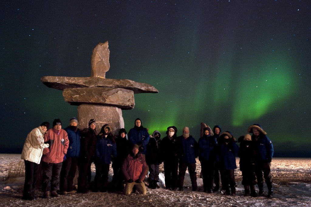 Ecstatic travelers take a group photo by the Hudson Bay.