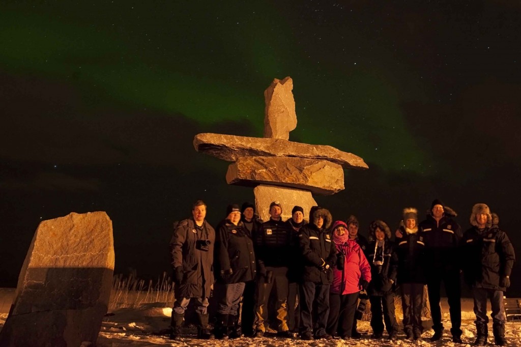 Inukshuk group photo with aurora over the bay. Colby Brokvist photo.