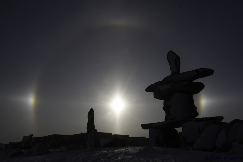 A sun dog over the tundra of Churchill, Manitoba. Inukshuk in the foreground.