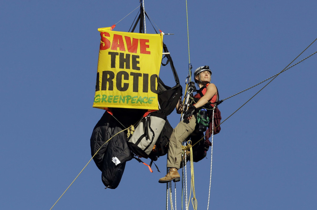 An activist looks towards the rising sun as she hangs from the St. Johns bridge as part of a protest to block the Royal Dutch Shell PLC icebreaker Fennica from leaving for Alaska in Portland, Ore., Thursday, July 30, 2015. The icebreaker, which is a vital part of Shell's exploration and spill-response plan off Alaska's northwest coast, stopped short of the hanging blockade, turned around and sailed back to a dock at the Port of Portland. (AP Photo/Don Ryan) ORDR106 (Don Ryan / The Associated Press)