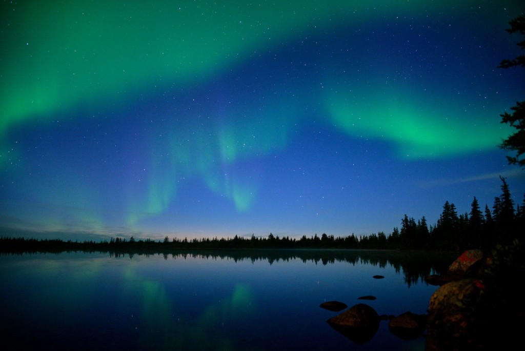 Subtle yet vibrant northern lights in a pale blue sky. Alex De Vries - Magnifico photo.